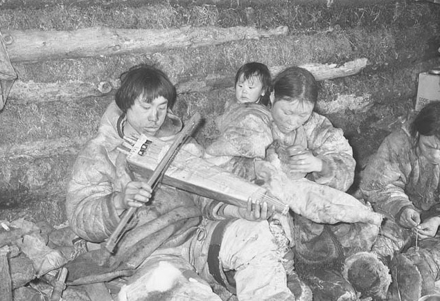 
        Image 2: Mother with baby in <i>amautik</i> (middle), 1949-50, Padlei region, Nunavut. Photo: Richard Harrington / Library and Archives Canada / PA-130005      