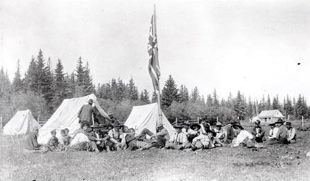 
        
        Image 1: Chipewyan (Denesuline) people receiving <i>treaty money</i> under Treaty 8 in Portage La Loche, Saskatchewan, circa 1911. The HBC residence is shown on the top right. Source: Wikimedia Commons. Photo: Unknown           